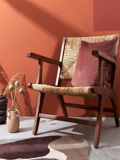 mur terracotta, chaise en osier, coussin rouge bordeaux