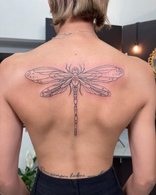 tatouage de libellule sur le dos d'une femme